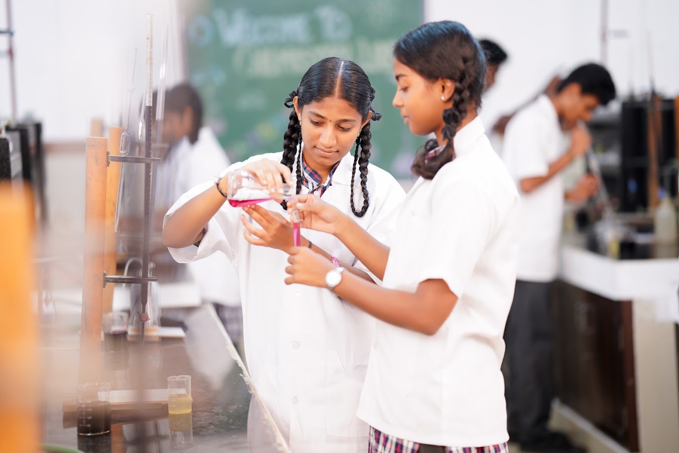 Students carrying out a chemistry experiment under supervision